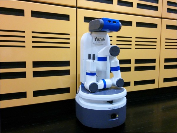 A white and blue robot with a an arm and gripper folded in front of it